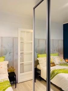 um quarto com 2 camas e um espelho em PARIS /LA DÉFENSE 5 MM DE L’ARC DE TRIOMPHE em Courbevoie