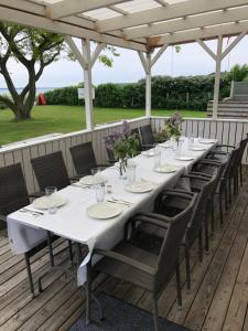 una mesa larga en una terraza con sillas y flores en Pinnebergheim en Haderslev