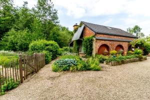 un jardin avec une maison en briques et une clôture dans l'établissement Raesborre, à Louvain