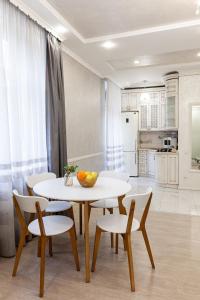une salle à manger avec une table et des chaises ainsi qu'une cuisine dans l'établissement Апартаменти з балконом і парковкою, à Lviv