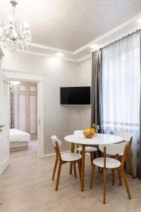 - un salon avec une table, des chaises et une télévision dans l'établissement Апартаменти з балконом і парковкою, à Lviv