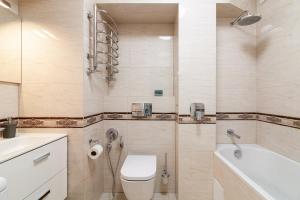 La salle de bains est pourvue de toilettes, d'un lavabo et d'une baignoire. dans l'établissement Апартаменти з балконом і парковкою, à Lviv