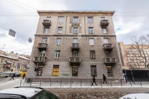 - un grand bâtiment en briques avec des personnes qui marchent devant dans l'établissement Апартаменти з балконом і парковкою, à Lviv