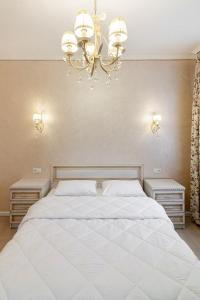 - une chambre avec un grand lit blanc et 2 tables de chevet dans l'établissement Апартаменти з балконом і парковкою, à Lviv