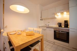 cocina con mesa de madera y cocina con fogones en Ferienwohnung Sanddorn - Strandhaus Lobbe, en Lobbe