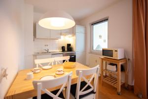 cocina y comedor con mesa de madera y sillas en Ferienwohnung Sanddorn - Strandhaus Lobbe, en Lobbe