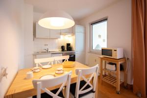 eine Küche und ein Esszimmer mit einem Holztisch und Stühlen in der Unterkunft Ferienwohnung Sanddorn - Strandhaus Lobbe in Lobbe + 6 Fotos