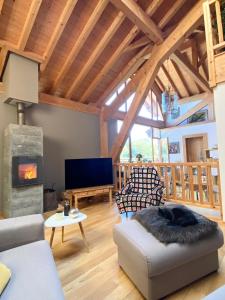 sala de estar con sofá y chimenea en Chez La Nanie, en Saint-Paul-en-Chablais