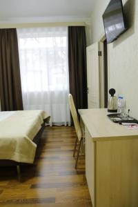 a hotel room with a bed and a kitchen with a counter at Магия КМВ in Kislovodsk