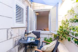 a small balcony with a table and a window at Apartments Villa Providenca in Dubrovnik