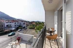 a balcony with chairs and tables and a view of a city at Apartments Villa Providenca in Dubrovnik