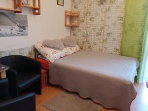 a small bedroom with a bed and a chair at Pokoje u Adama i Ewy in Szczawnica