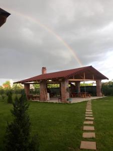 a rainbow in front of a building with a lawn at Garden Pypa in Vânătorii Mici