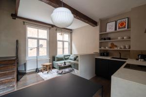 uma cozinha e sala de estar com um sofá e uma mesa em Charming House in Le Sablon em Bruxelas