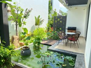 a patio with a pond with chairs and plants at Oceanami Villas & Beach Club Long Hai at 1, 3, 4 Bedroom & 5, 6 Bedroom Beachfront private pool in Long Hai