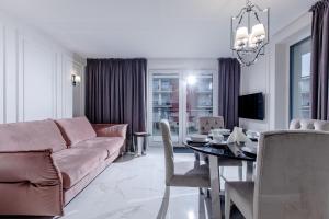 ein Wohnzimmer mit einem Sofa und einem Tisch in der Unterkunft Resort Apartamenty Klifowa Rewal 72 in Rewal