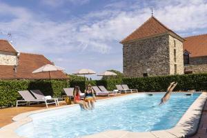 Deux femmes sont assises dans une piscine dans l'établissement Hotel Les Suites - Domaine de Crécy, à Crécy-la-Chapelle