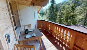 a porch with a table and chairs on a balcony at Appartement Hauser in Zell am Ziller
