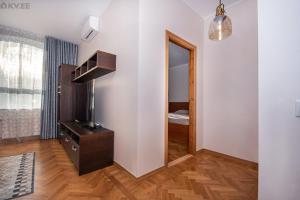 Habitación con espejo y tocador con TV. en Stylish apartment in the heart of Pärnu, en Pärnu