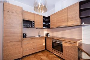 cocina grande con armarios de madera y fregadero en Stylish apartment in the heart of Pärnu, en Pärnu