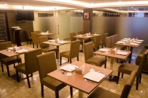 a dining room with tables and chairs in a restaurant at Hotel Comfotel Kolkata in Kolkata