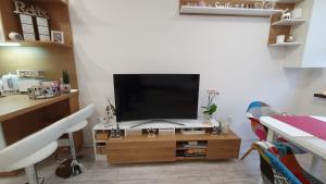 a living room with a television on a wooden table at Borovets Cozy Mountain Apartments in Borovets +35 photos