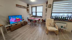 a living room with a tv and a table and chairs at Borovets Cozy Mountain Apartments in Borovets