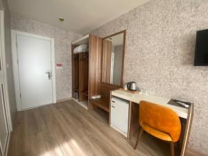 a room with a desk with a chair and a mirror at ERA PALACE HOTEL B BLOK in Istanbul