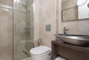 La salle de bains est pourvue d'un lavabo, de toilettes et d'une douche. dans l'établissement Crist Luxury Apartments, à Potidée