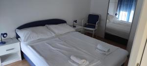 um quarto com uma cama branca e toalhas em Astralis Factory Apartments-Marineta em Zagreb