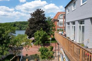 einen Balkon eines Hauses mit Flussblick in der Unterkunft Hotel Holsteinische Schweiz am Dieksee in Malente