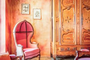 a room with a red chair and a wooden cabinet at Hôtel Du Théâtre Centre Historique - Parking Souterrain Public Gratuit in Metz