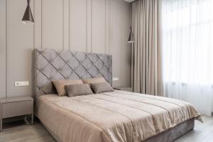 een slaapkamer met een groot bed met een grijs hoofdeinde bij Hotel & Restauracja Timberland in Orzesze