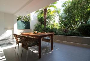 een houten tafel en stoelen op een patio bij Modern apartment Zen with private garden in Poreč