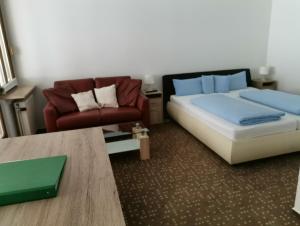 1 dormitorio con cama, sofá y mesa en Aparthotel Kupferkanne, en Todtmoos