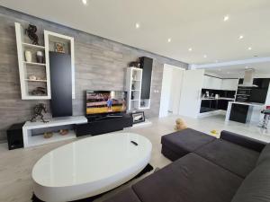 a living room with a couch and a tv at Villa ARUBA in Balchik