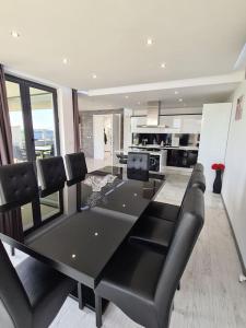 a dining room with a black table and black chairs at Villa ARUBA in Balchik
