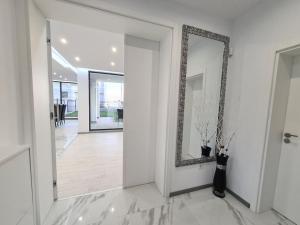 a hallway with a mirror and a vase on the floor at Villa ARUBA in Balchik