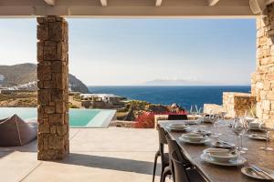 a dining table with a view of the ocean at Anarina Villas & Suites Mykonos Elia Beach in Elia Beach