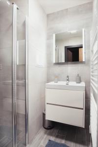 a bathroom with a white sink and a mirror at Apartmány Štiavnica & Ďurková - Galeria Apartments Jasná Lúčky in Demanovska Dolina