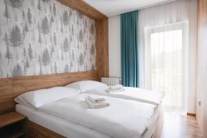 a bedroom with a bed with two towels on it at Apartmány Štiavnica & Ďurková - Galeria Apartments Jasná Lúčky in Demanovska Dolina
