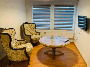 a living room with two chairs and a table at Apartment Marielena in Püttlingen