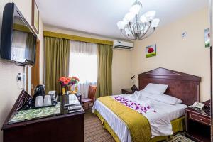 a hotel room with a bed and a flat screen tv at Victoria Hotel in Dubai