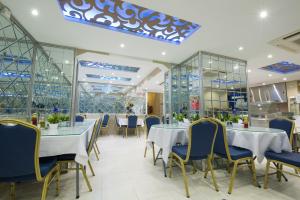 a restaurant with tables and chairs and glass walls at Victoria Hotel in Dubai