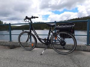 a bike parked next to a fence near a body of water at Casa do Abade - Country House in Viseu