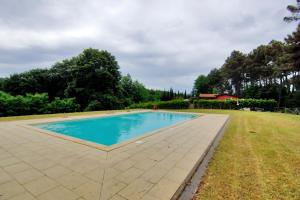 a swimming pool in the middle of a grass field at Relais jardin San Vivaldo in San Vivaldo