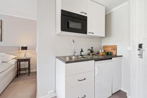 una cucina bianca con lavandino e forno a microonde di Victoria Apartments - Fredrikstad a Fredrikstad