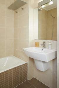 a bathroom with a sink and a tub and a mirror at Esnatuz - Basque Stay in San Sebastián