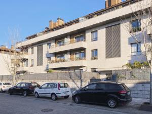 eine Gruppe von Autos, die vor einem Gebäude geparkt sind in der Unterkunft Esnatuz - Basque Stay in San Sebastián