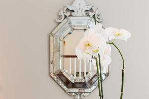 a mirror with white flowers in front of it at Hotel Kaiserhof Wien in Vienna